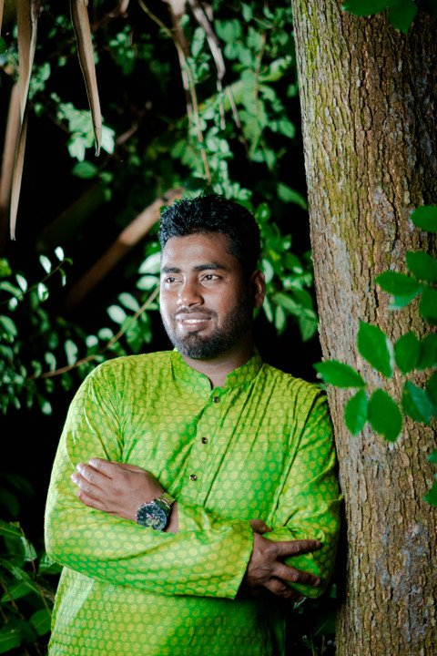 A lime silk kurta, leaning on a tree.