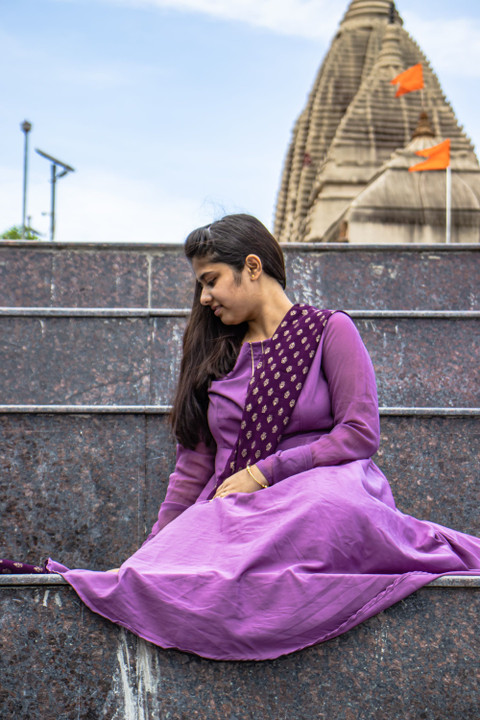 An amethyst saree on temple steps.
