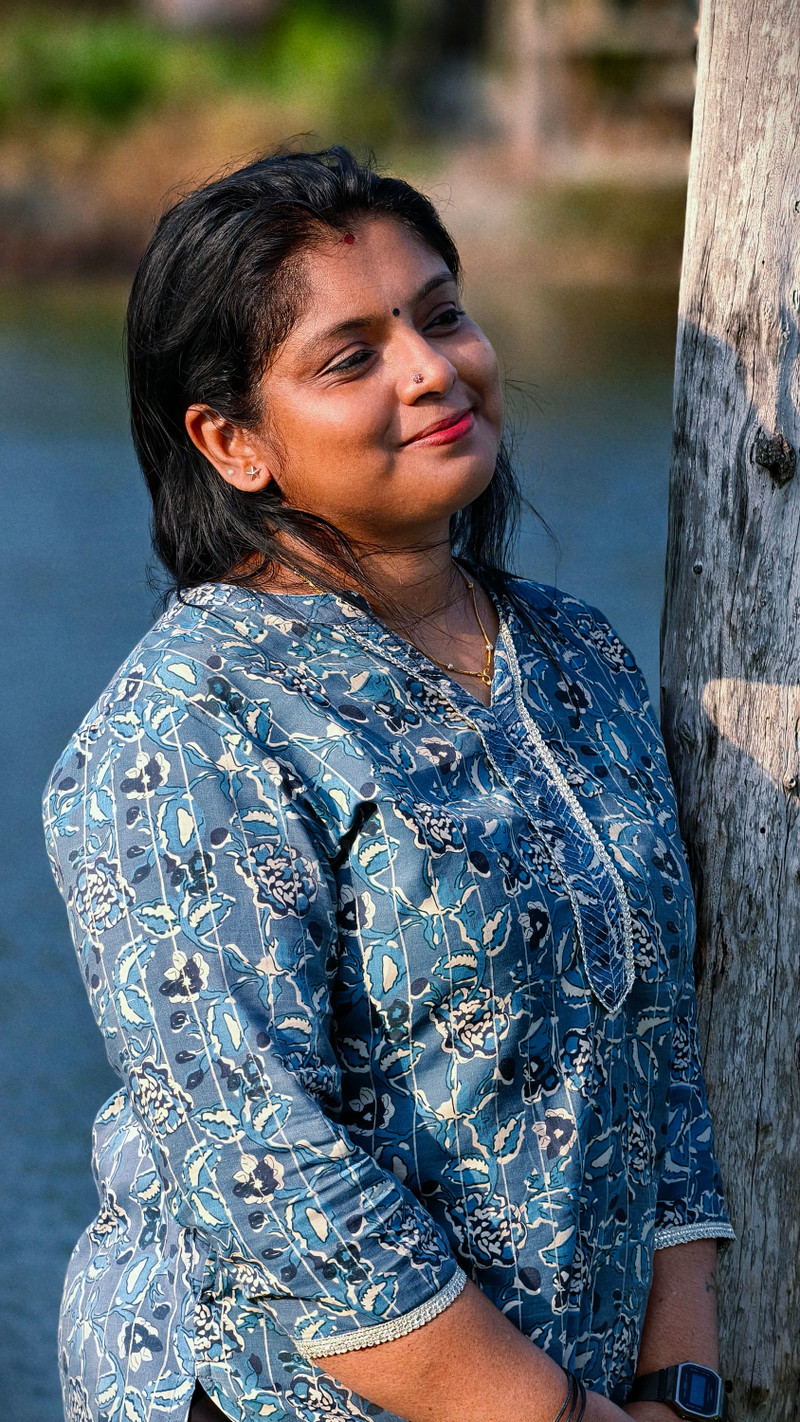 The indigo kurta, leaning on a tree.