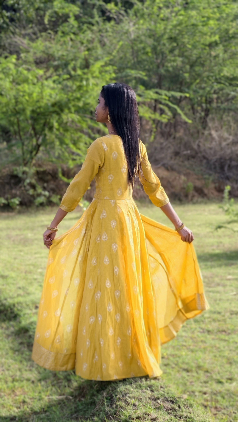 The mustard anarkali from the back, its flare spread.