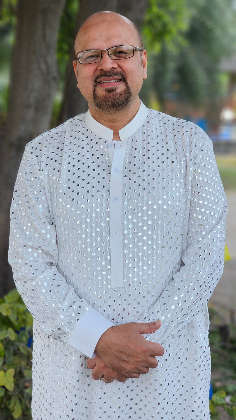 A white chikankari kurta, close, in a garden.