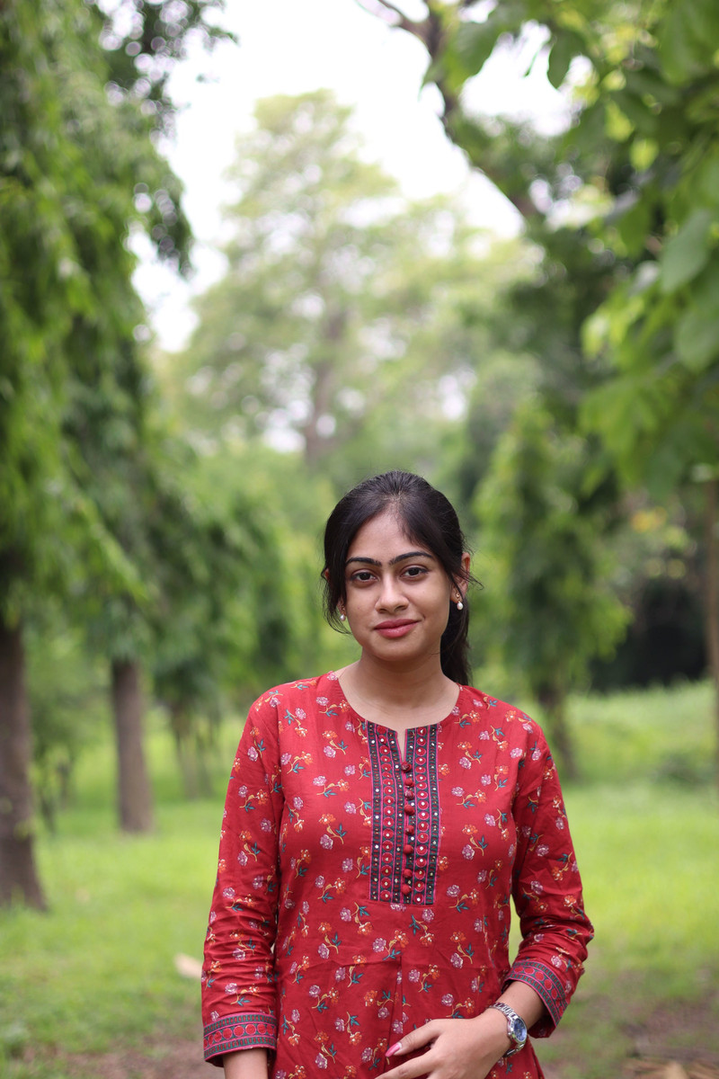 The red kurta, a hand at the collar.
