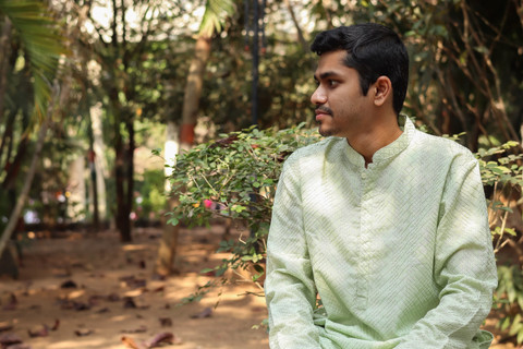 A pista green kurta, seated in a park.