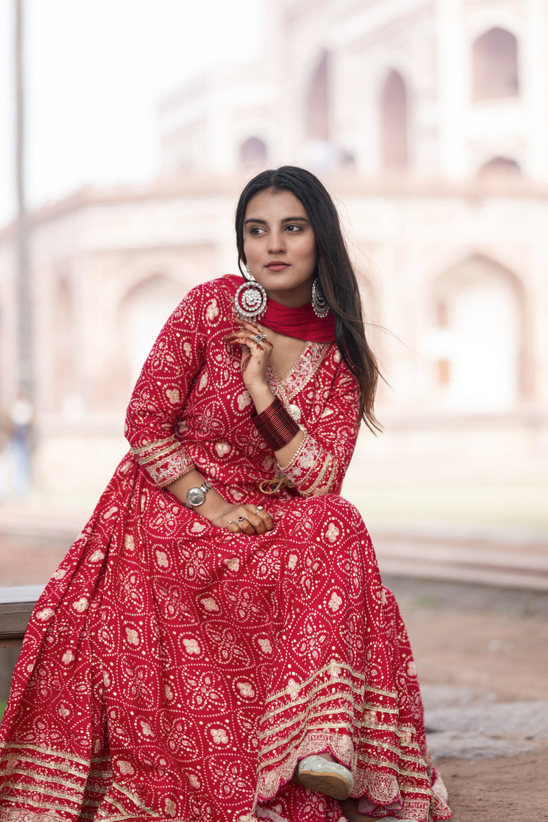 The red bandhani anarkali, seated, its border spread.