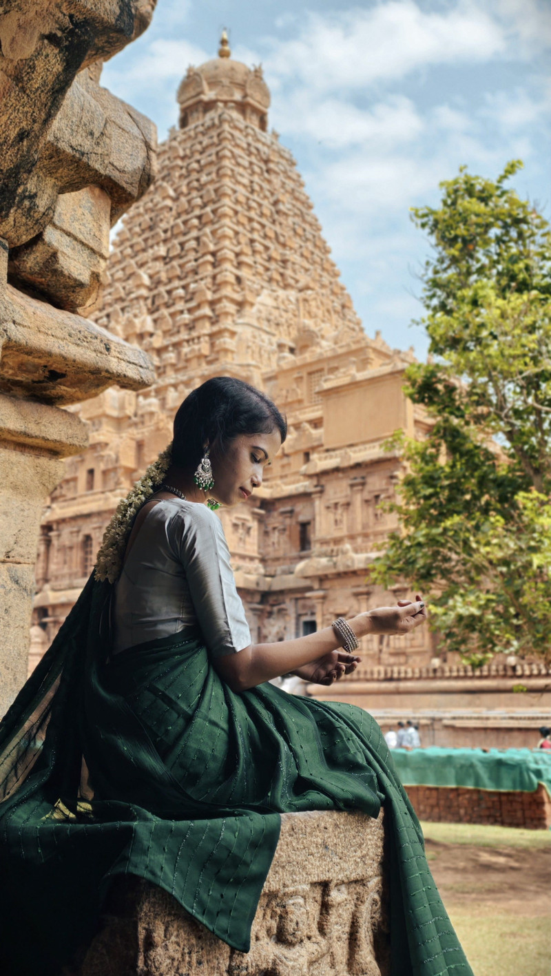 The emerald silk saree, seated by the temple.