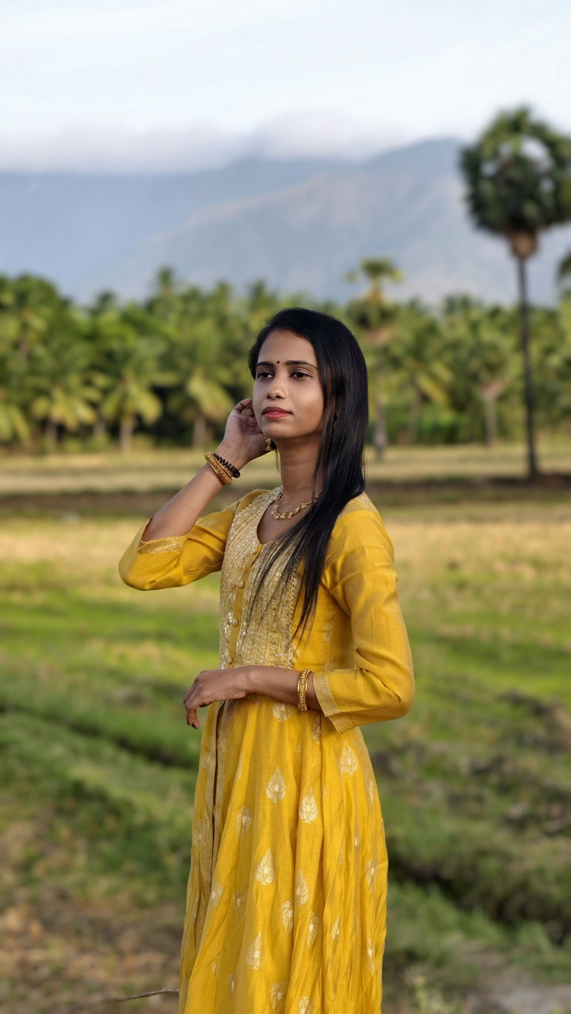 A yellow straight kurta set in a green field.