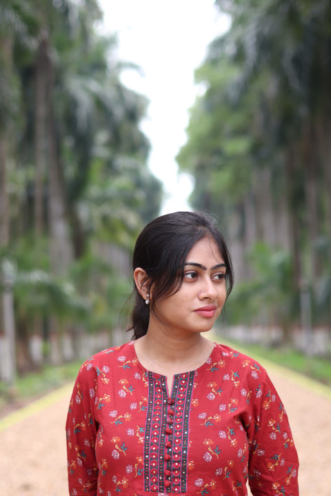 A red kurta with a yoke of thread work, in a palm grove.
