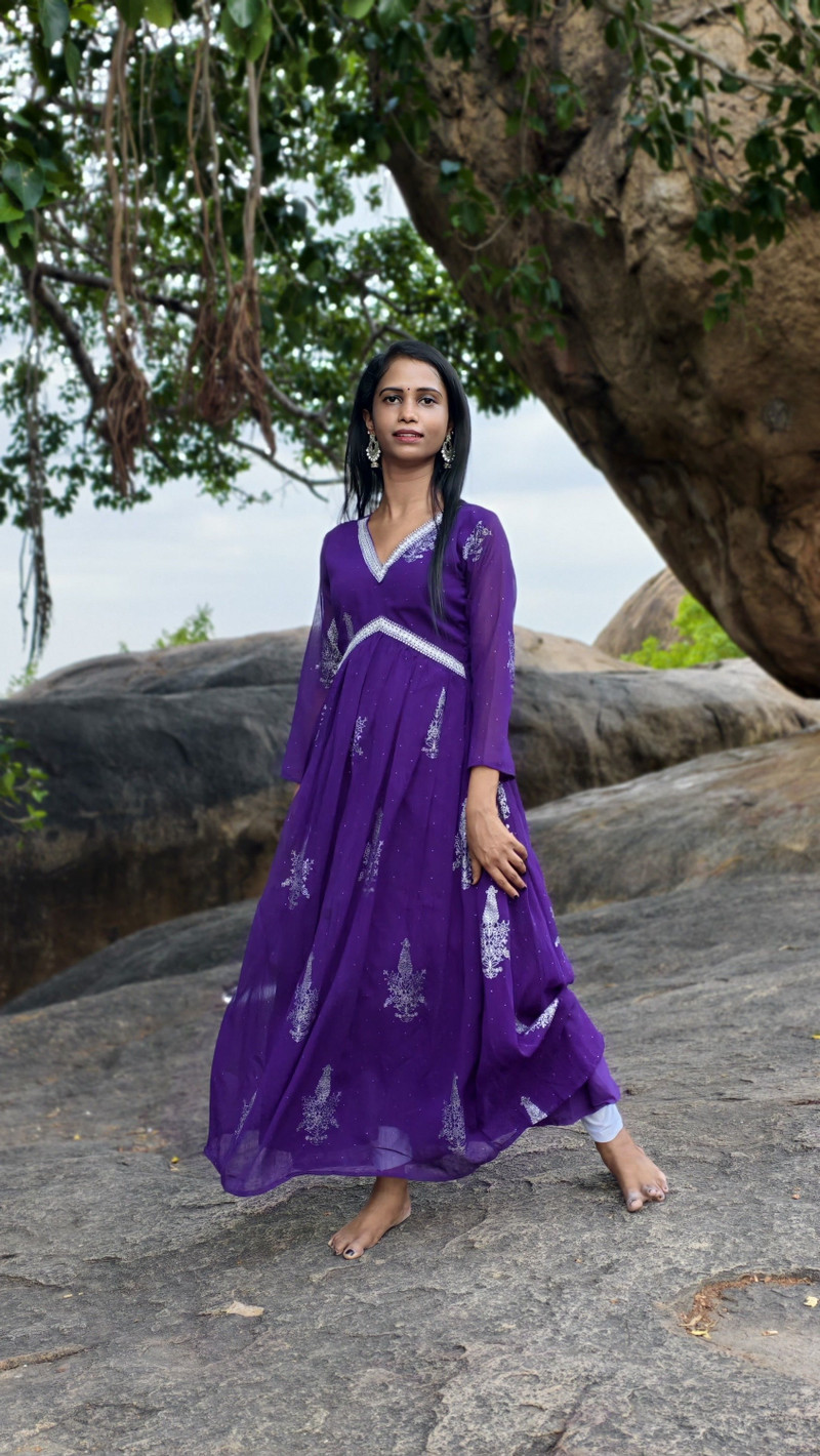 The violet anarkali against the rocks.